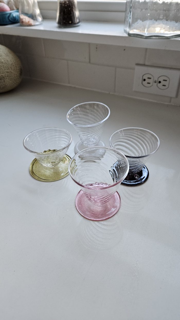 Four small spiral glasses with colored bases